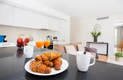 a table with a plate of bread and two glasses of orange juice at Durlet Beach Apartments in Barcelona
