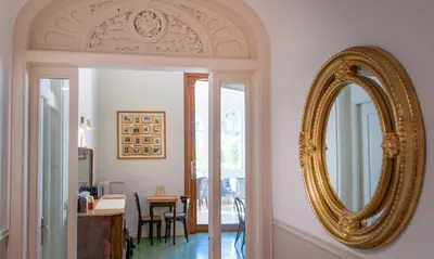 a gold mirror on a wall next to a door at Mihlton Barcelona Boutique B&B in Barcelona