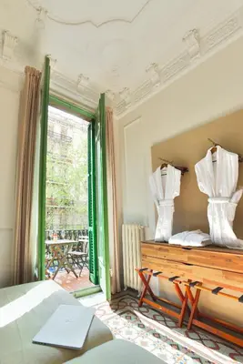 a bedroom with a bed and a window with curtains at Mihlton Barcelona Boutique B&B in Barcelona