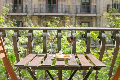 a table with two glasses of wine and a plate of food at Mihlton Barcelona Boutique B&B in Barcelona