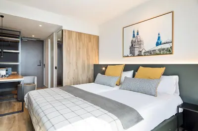 a bedroom with a large bed and a desk at Acta Voraport in Barcelona
