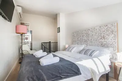 a bedroom with a large bed with a brick wall at Tendency Apartments 8 in Barcelona