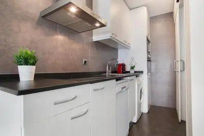 a kitchen with white cabinets and a sink at Tendency Apartments 8 in Barcelona