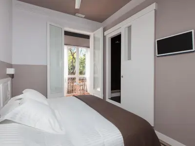 a white bedroom with a bed and a window at Ecozentric in Barcelona