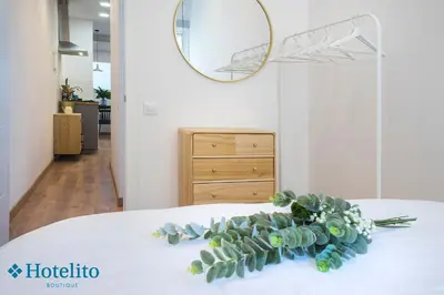 a bouquet of flowers on a bed with a mirror at Hotelito Boutique Badalona Mar in Badalona