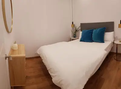 a bedroom with a large white bed with blue pillows at Hotelito Boutique Badalona Mar in Badalona