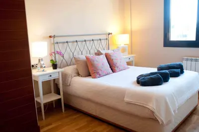 a bedroom with a bed with blue pillows on it at Alcam Barbera Terrazas in Barbera del Valles