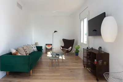 a living room with a green couch and a table at Casa Cosi - Atico in Barcelona