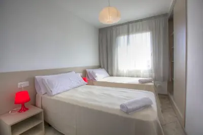 two beds in a small room with a window at Sono Master Apartments in La Garriga