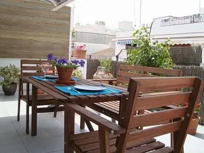 a wooden table and chairs on a patio at Sunny Apartments in Sitges
