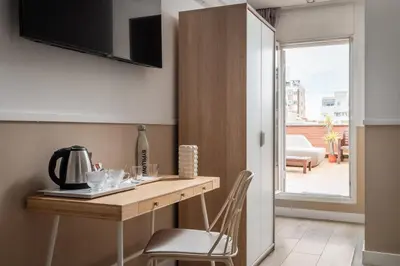 a kitchen with a wooden table and a chair at BYPILLOW House in Barcelona