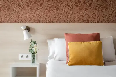 a bedroom with a bed with a yellow pillow and a table at BYPILLOW House in Barcelona