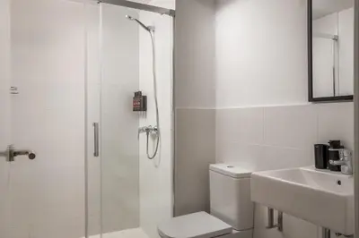 a bathroom with a shower and a toilet and a sink at BYPILLOW House in Barcelona
