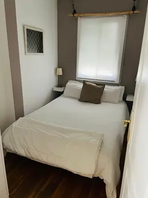 a bedroom with a white bed with a window at Sweet Atic in Sitges