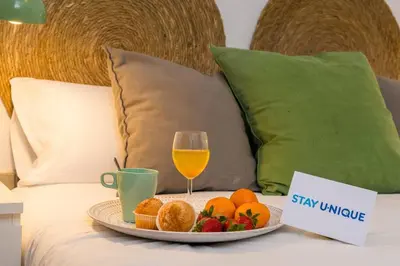a tray of fruit and a glass of wine on a bed at Stay U-nique Apartments Provença in Barcelona