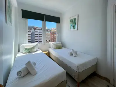 two beds in a small room with a window at Stay U-nique Apartments Sèneca in Barcelona
