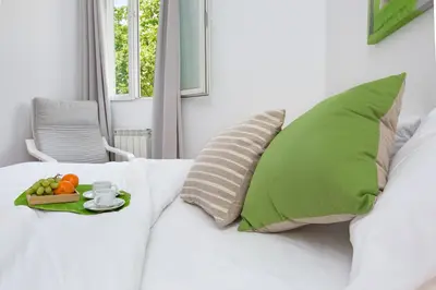 a white couch with a tray of fruit on it at Stay U-nique Apartments Sicília in Barcelona