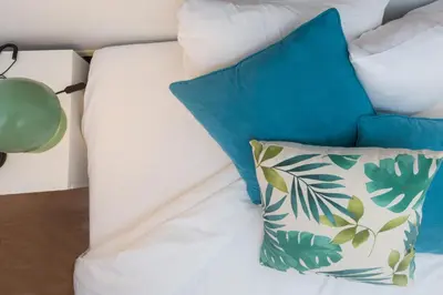 a bed with blue and white pillows and a lamp at Stay U-nique Apartments Sicília in Barcelona