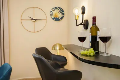 a bar with two chairs and wine glasses and a clock at Stay U-nique Apartments Floridablanca in Barcelona
