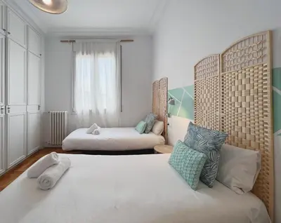 a bedroom with two beds and a couch at Stay U-nique Apartments Roger Llúria in Barcelona