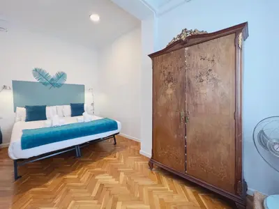 a bedroom with a bed and a large wooden cabinet at Stay U-nique Apartments Roger Llúria in Barcelona