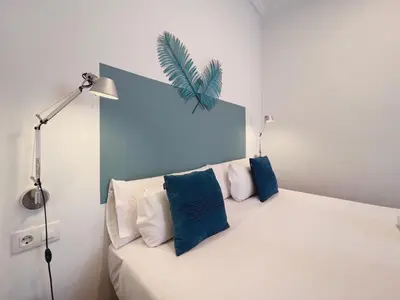 a bedroom with a bed with blue and white pillows at Stay U-nique Apartments Roger Llúria in Barcelona
