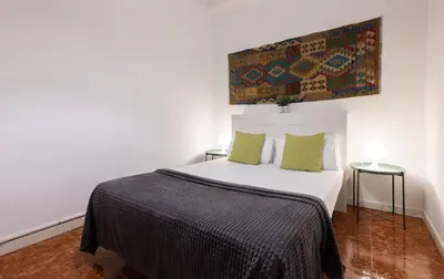 a bedroom with a white bed with green pillows at Stay U-nique Apartments Casanova in Barcelona