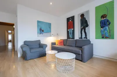 a living room with two couches and paintings on the wall at Stay U-nique Apartments Casanova in Barcelona