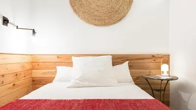 a bedroom with a white bed with a red blanket at Brummell Apartments Eixample Izquierda/Valeris in Barcelona