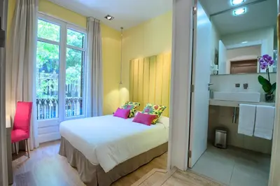 a bedroom with a bed with pink pillows and a window at BacHome Terrace B&B in Barcelona