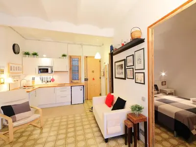a living room with a couch and a bed and a kitchen at Apartment Eixample Dret Valencia - Cartagena by Interhome in Barcelona