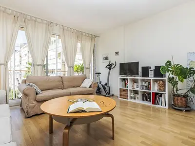 a living room with a couch and a table with a book at Apartment Vila Olimpica Sant Marti by Interhome in Barcelona