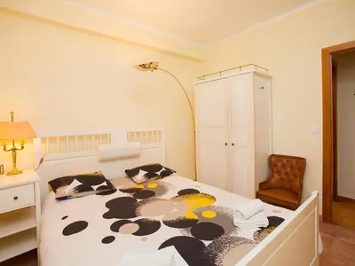 a bedroom with a bed and a lamp and a chair at Apartment Sardenya - Casp by Interhome in Barcelona