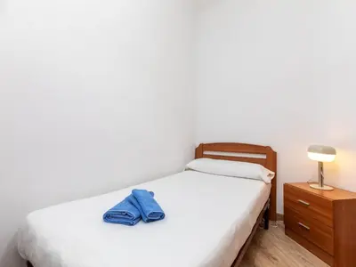 a bedroom with a bed with a blue towel on it at Apartment Eixample Esq Rocafort Diputacio by Interhome in Barcelona