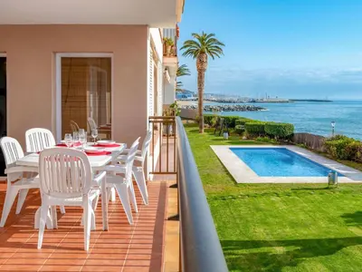a balcony with a table and chairs and a swimming pool at Apartment Blaumar by Interhome in Sant Andreu de Llavaneres