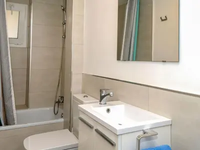 a bathroom with a sink and a toilet and a mirror at Apartment Blaumar by Interhome in Sant Andreu de Llavaneres