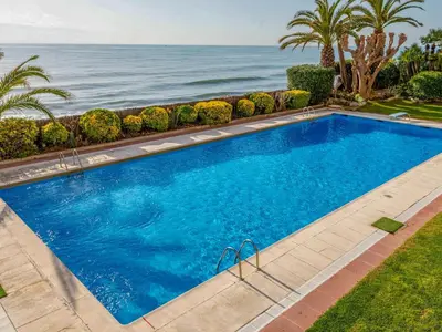 a swimming pool with the ocean in the background at Apartment Blaumar by Interhome in Sant Andreu de Llavaneres