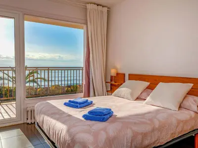 a bedroom with a bed and a large window at Apartment Blaumar by Interhome in Sant Andreu de Llavaneres