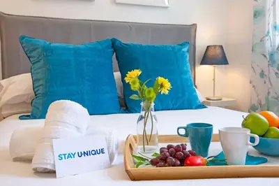 a tray of fruit and a vase of flowers on a bed at Stay U-nique Apartments Ricart in Barcelona