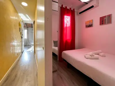 a small room with two beds and a red curtain at Stay U-nique Apartments Fontrodona in Barcelona
