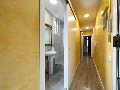 two views of a bathroom with yellow walls and a sink at Stay U-nique Apartments Fontrodona in Barcelona