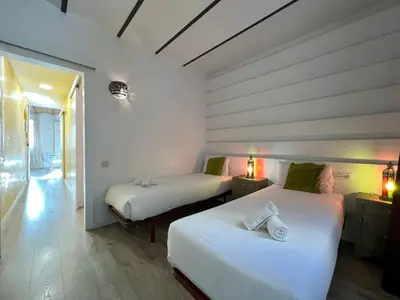 two beds in a room with white walls and wood floors at Stay U-nique Apartments Fontrodona in Barcelona