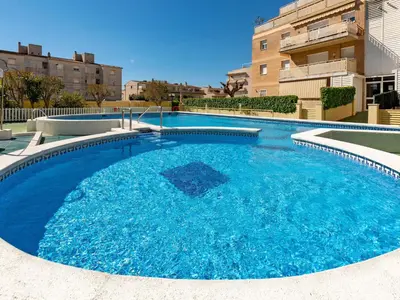 a large pool with blue water in front of a building at Apartment Aires de mar by Interhome in Cunit