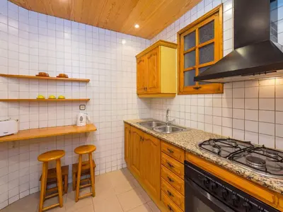a kitchen with wooden cabinets and a stove top oven at Apartment Eixample Esquerre Arago Rocafort by Interhome in Barcelona