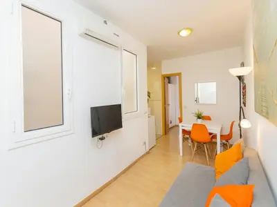 a living room with a couch and a tv on a wall at Apartment Eixample Dret Sagrada Familia by Interhome in Barcelona