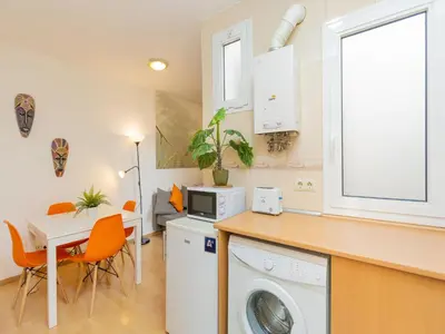 a kitchen with a washing machine and a table at Apartment Eixample Dret Sagrada Familia by Interhome in Barcelona