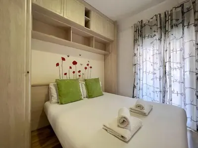 a bedroom with a white bed with green pillows at Stay U-nique Apartments Sardenya II in Barcelona
