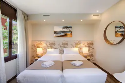 a bedroom with two beds and a mirror at Eixample Building Apartments by Mercedes Heritage in Barcelona