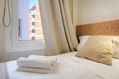 a bed with two towels on it with a window at Eixample Building Apartments by Mercedes Heritage in Barcelona