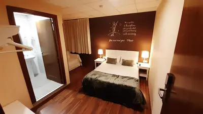 a bedroom with a bed and two tables and a mirror at Hostal Petit Príncep in Barcelona